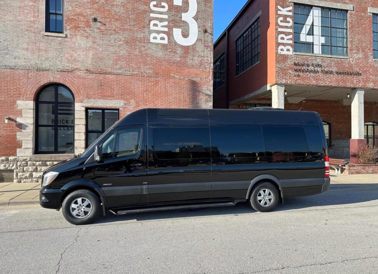 California Wine Tours black Mercedes Sprinter van parked in front of brick building, ready for private wine tour travel