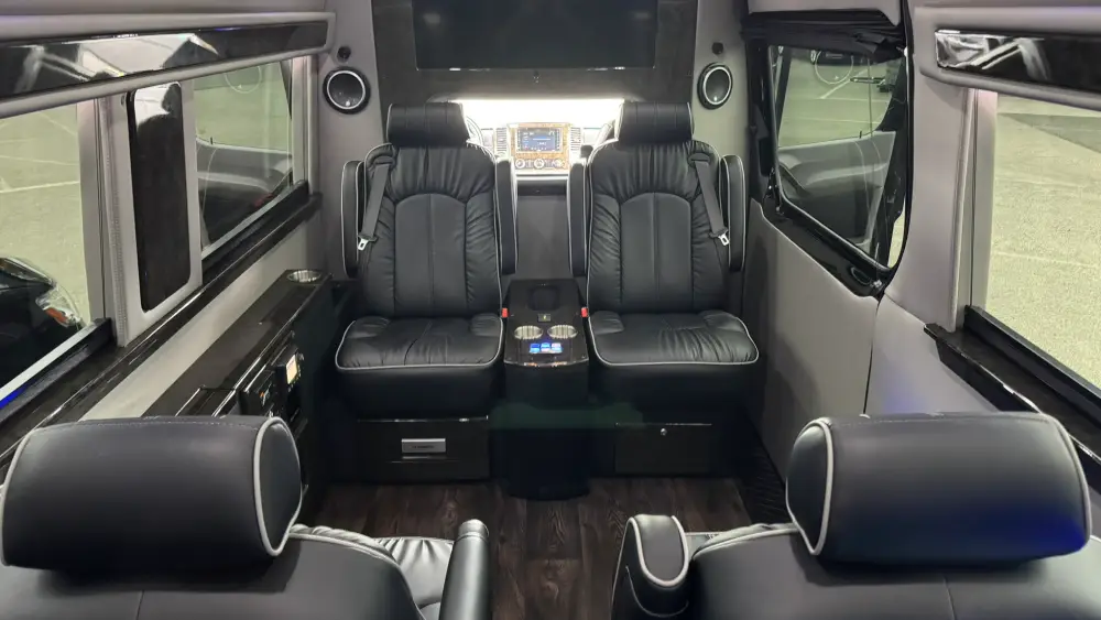 Black leather captain chairs and console seating inside a private luxury van used by California Wine Tours for small groups