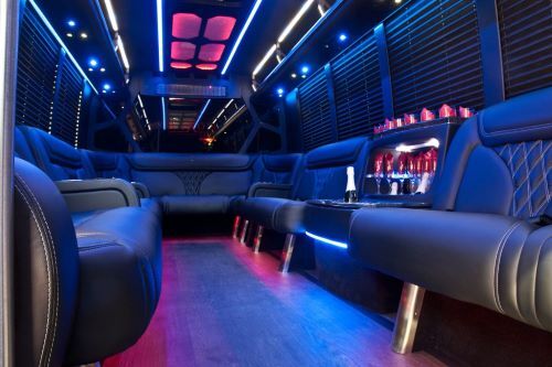 Interior of luxury party bus with LED lighting and bar setup, used for stylish airport transportation to Napa for groups.