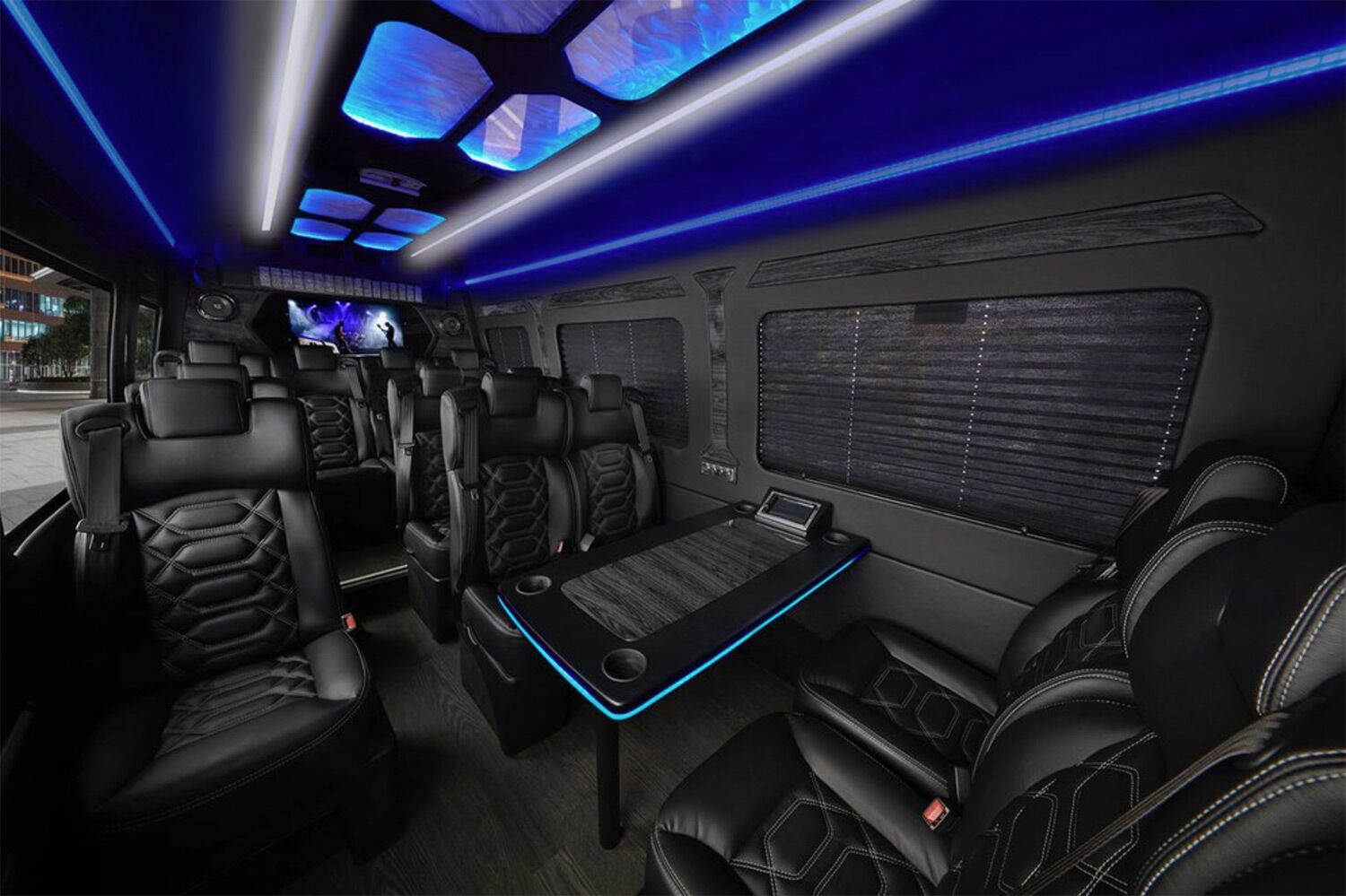 Executive shuttle interior with black leather seating, LED lights, and table for corporate transportation in Napa Valley.
